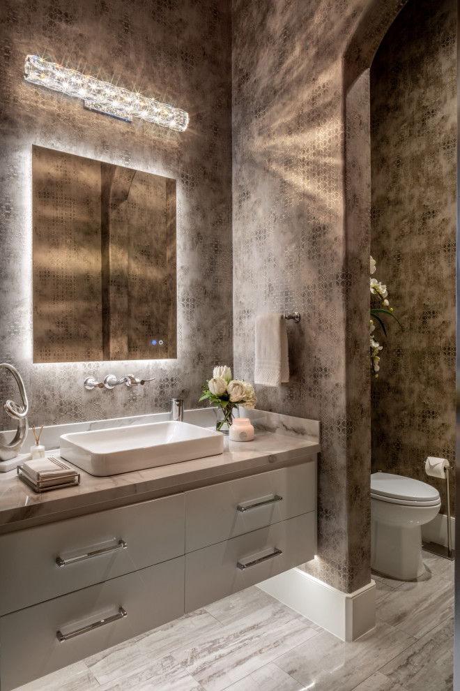 This is an example of a medium sized mediterranean cloakroom in Houston with ceramic flooring, quartz worktops, a floating vanity unit, wallpapered walls, flat-panel cabinets, grey cabinets, grey walls, a vessel sink, grey floors and grey worktops.