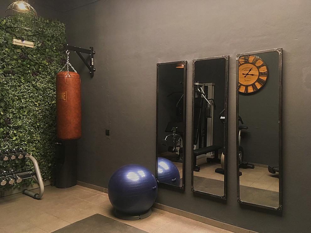 Photo of a small industrial multipurpose gym in Barcelona with grey walls, ceramic floors and grey floor.