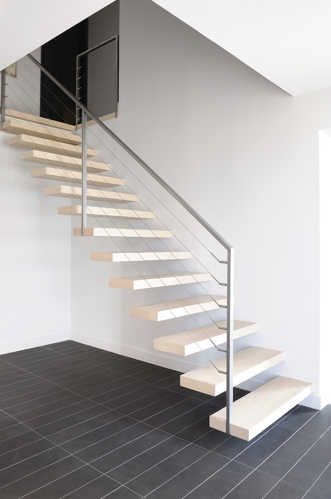 Mid-sized contemporary wood floating staircase in Montreal with open risers and cable railing.