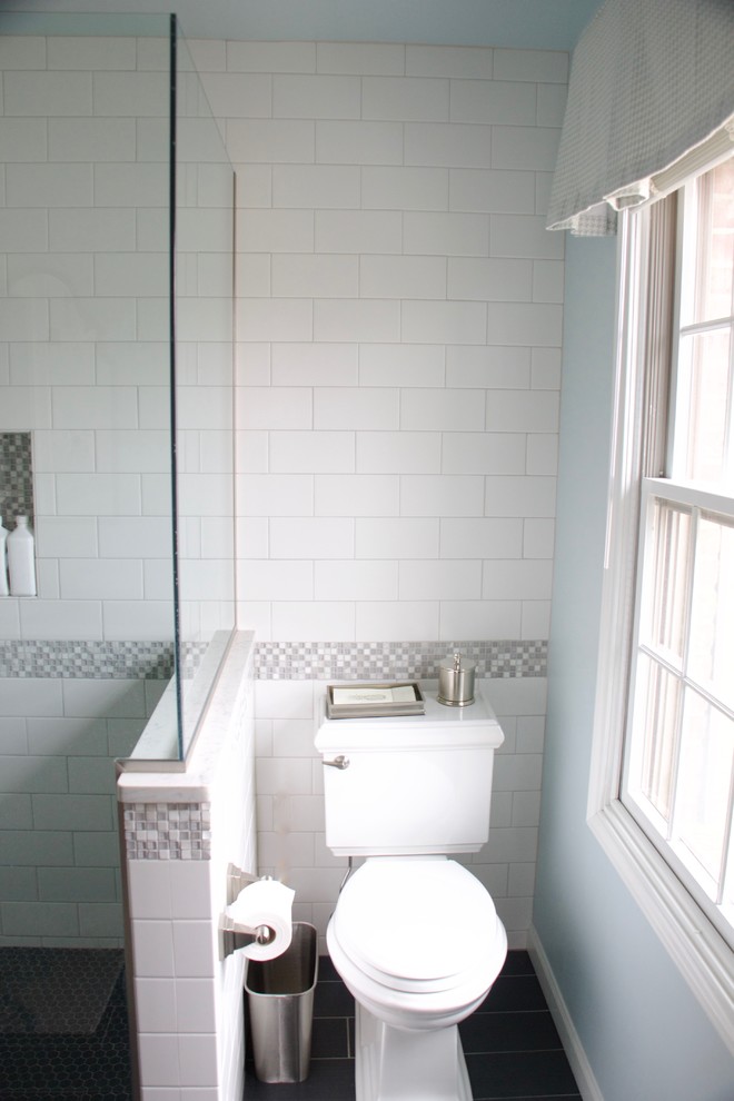 Corner shower - small transitional master white tile and ceramic tile ceramic tile corner shower idea with shaker cabinets, dark wood cabinets, a two-piece toilet, blue walls, an undermount sink and quartz countertops