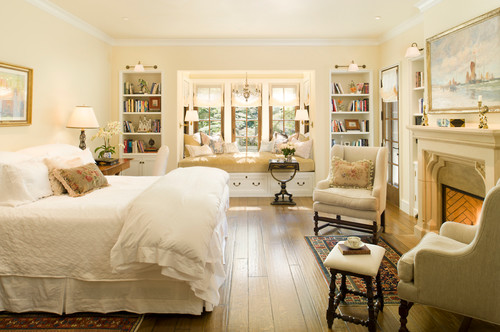 tradtional bedroom with fireplace and white bedding and white walls and wood flooring, traditional bedroom ideas