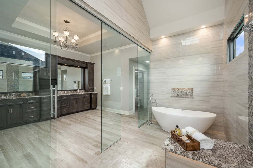 Photo of an expansive contemporary master wet room bathroom in Chicago with raised-panel cabinets, brown cabinets, a drop-in tub, a two-piece toilet, beige tile, ceramic tile, grey walls, ceramic floors, an undermount sink, granite benchtops, beige floor and a sliding shower screen.