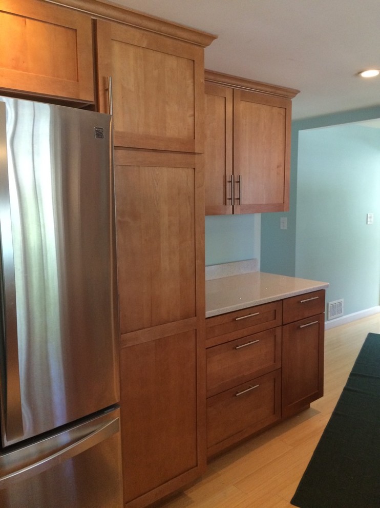 Example of a transitional galley light wood floor eat-in kitchen design in Boston with an undermount sink, shaker cabinets, medium tone wood cabinets, quartz countertops, stainless steel appliances, no island and white countertops