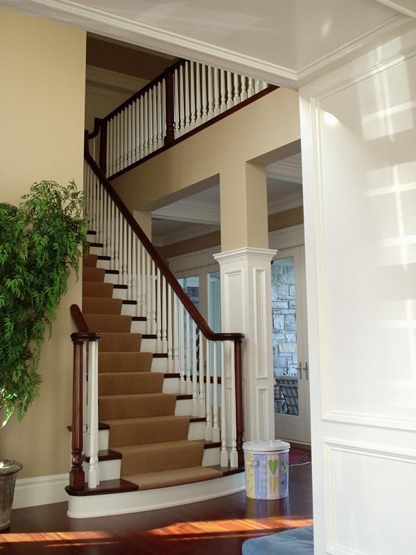 Photo of a mid-sized traditional wood straight staircase in London with painted wood risers.