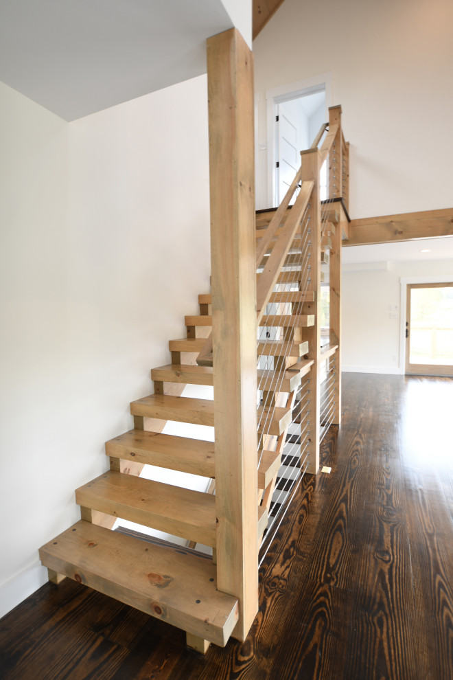 This is an example of a mid-sized country wood straight staircase in New York with wood risers and mixed railing.