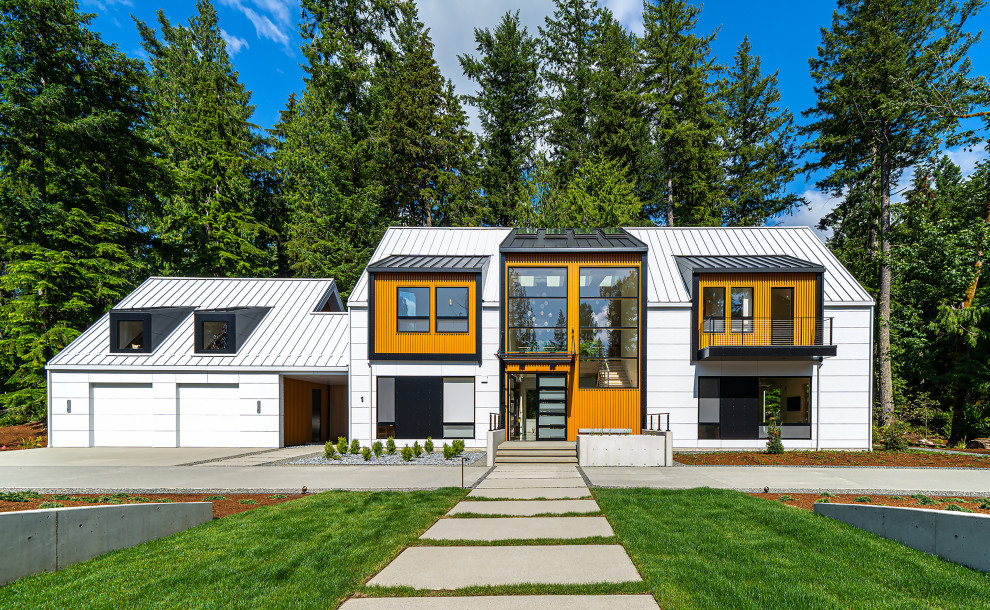 Cette image montre une façade de maison métallique et blanche urbaine en planches et couvre-joints de taille moyenne et à un étage avec un toit à deux pans, un toit en métal et un toit blanc.