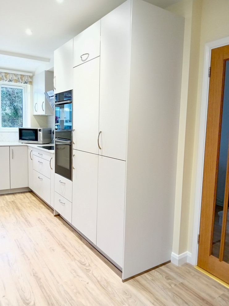 This is an example of a medium sized modern u-shaped kitchen/diner in Berkshire with flat-panel cabinets, grey cabinets, quartz worktops and white worktops.