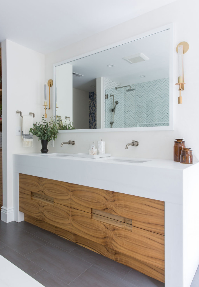 Photo of a contemporary bathroom in San Francisco with flat-panel cabinets, medium wood cabinets, an undermount sink, white benchtops, a double vanity, a built-in vanity, white walls and black floor.