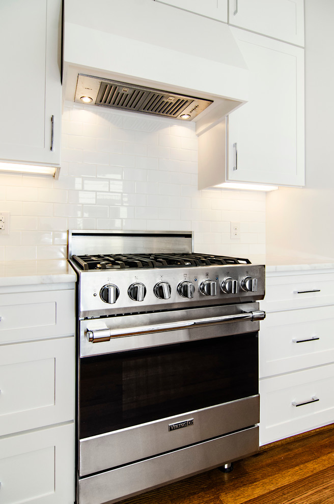 Transitional galley eat-in kitchen photo in Dallas with an undermount sink, shaker cabinets, white cabinets, marble countertops, white backsplash, subway tile backsplash and stainless steel appliances
