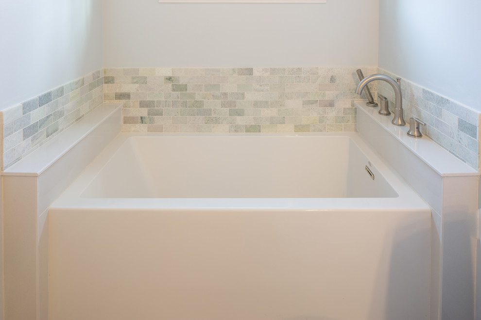 Inspiration for a mid-sized traditional bathroom in Detroit with shaker cabinets, grey cabinets, an alcove tub, a shower/bathtub combo, a one-piece toilet, beige tile, green tile, white tile, stone tile, beige walls, porcelain floors, an undermount sink, solid surface benchtops, grey floor and an open shower.
