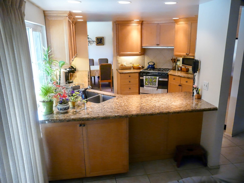 Inspiration for a mid-sized transitional l-shaped porcelain tile enclosed kitchen remodel in San Diego with recessed-panel cabinets, no island, an undermount sink, light wood cabinets, granite countertops, beige backsplash, porcelain backsplash and stainless steel appliances