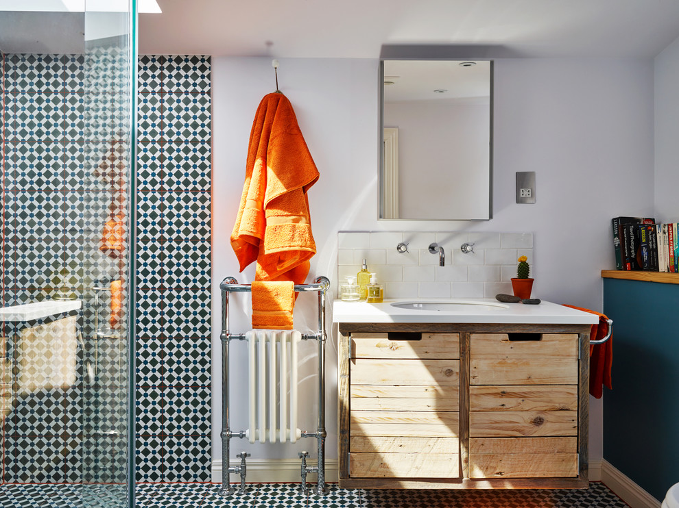 This is an example of an industrial 3/4 bathroom in Other with medium wood cabinets, a curbless shower, black and white tile, blue tile, subway tile, blue walls, an undermount sink, multi-coloured floor, an open shower and flat-panel cabinets.