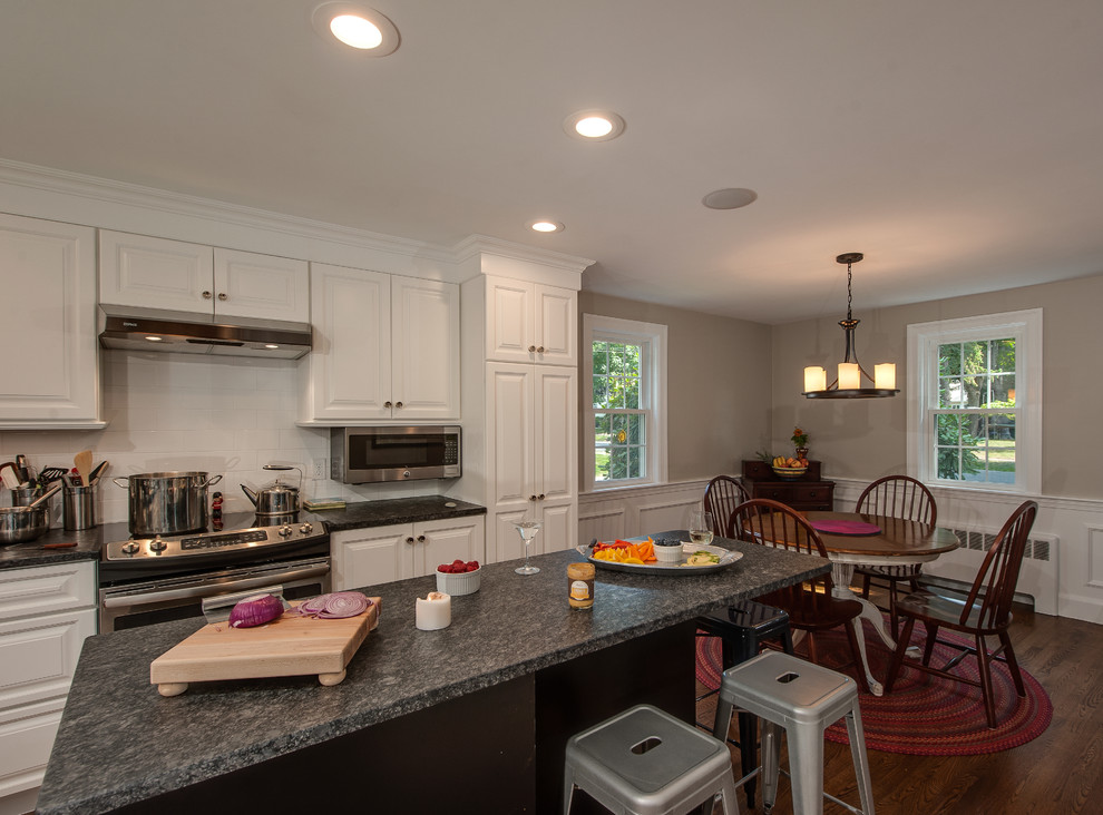 Inspiration for a traditional l-shaped eat-in kitchen in Boston with a single-bowl sink, white cabinets, granite benchtops, white splashback, subway tile splashback, stainless steel appliances, dark hardwood floors and with island.