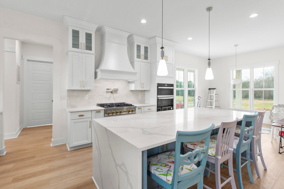 Example of a large transitional l-shaped open concept kitchen design in Richmond with a farmhouse sink, recessed-panel cabinets, quartz countertops, white backsplash, stainless steel appliances, an island and white countertops