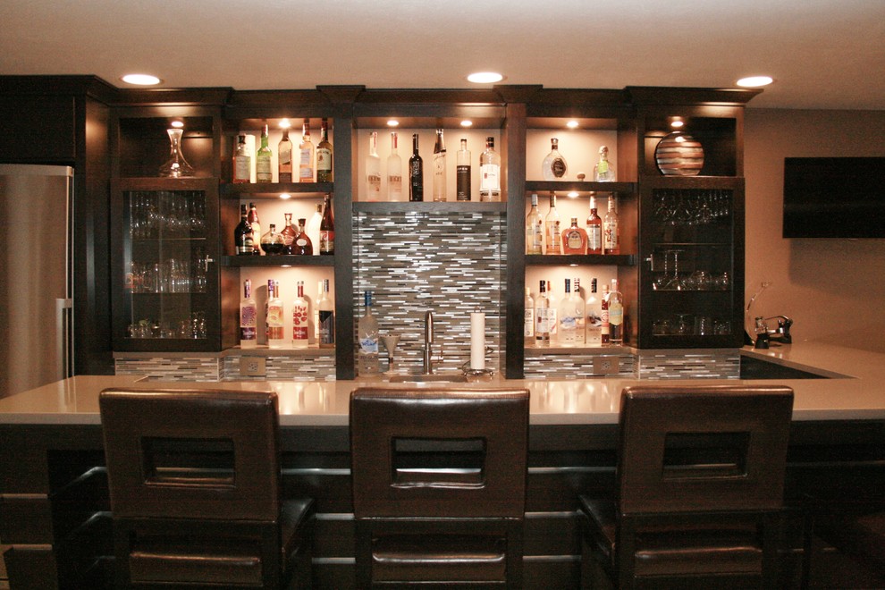 Mid-sized contemporary l-shaped seated home bar in Chicago with an undermount sink, glass-front cabinets, dark wood cabinets, quartzite benchtops, grey splashback, ceramic splashback and ceramic floors.