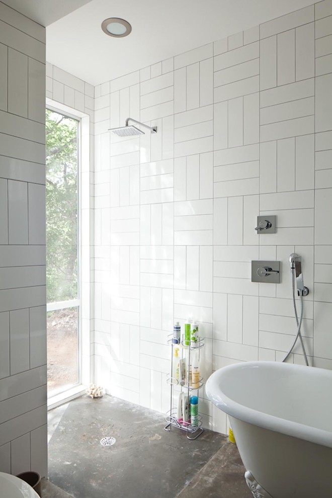 This is an example of a contemporary bathroom in Austin with a freestanding tub and subway tile.