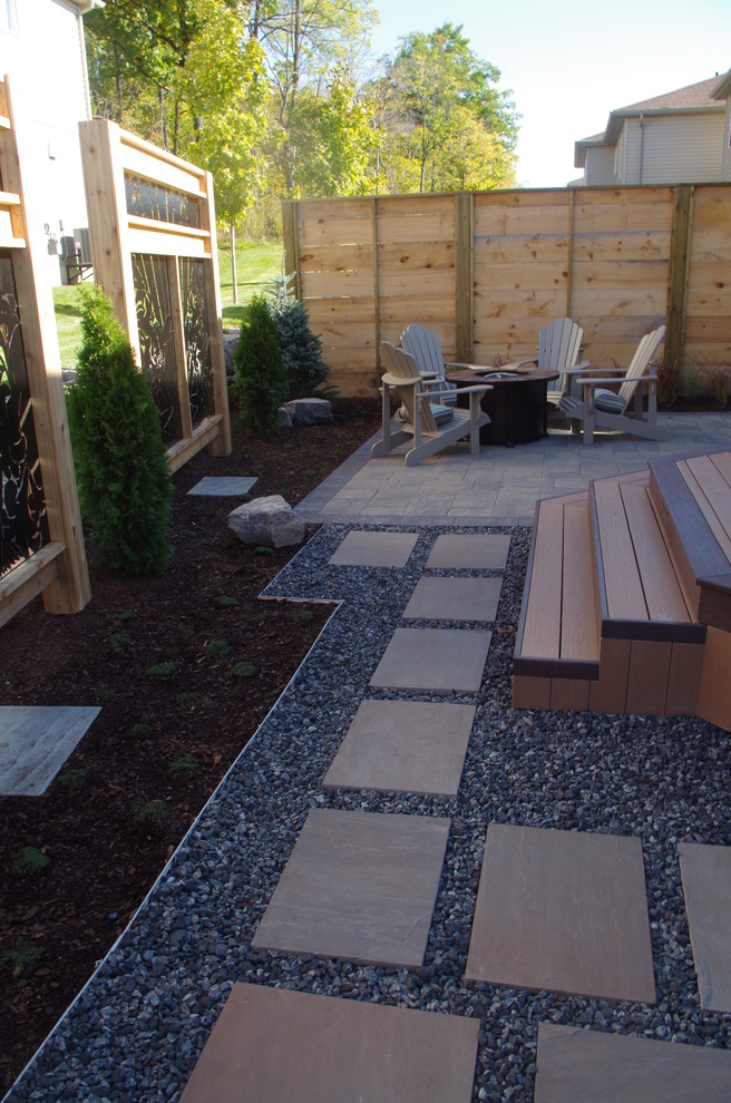 Inspiration for a mid-sized modern backyard shaded garden in Toronto with natural stone pavers.