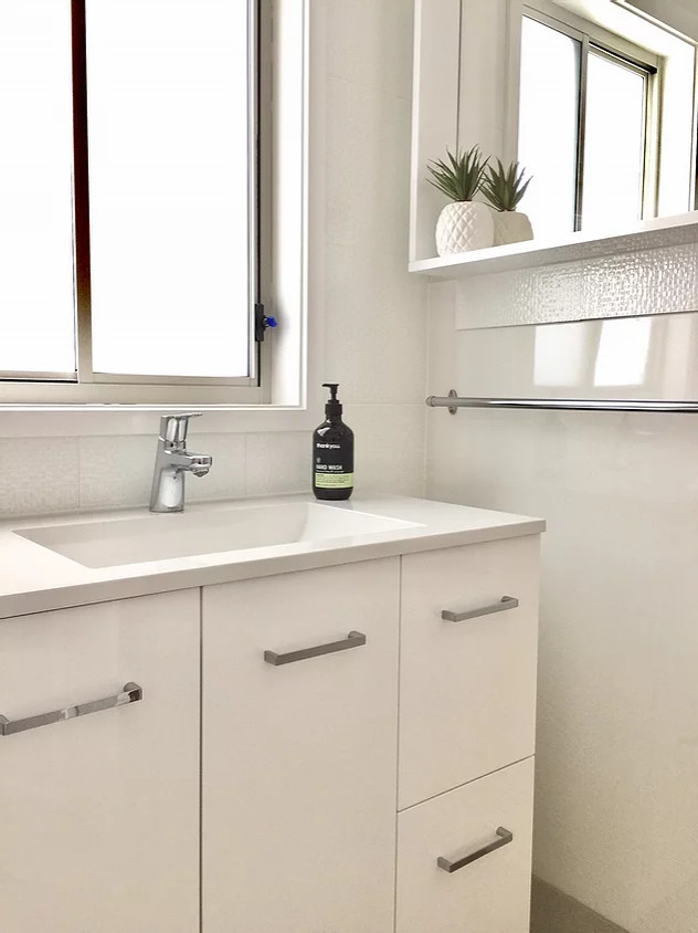 This is an example of a small traditional 3/4 bathroom in Gold Coast - Tweed with furniture-like cabinets, white cabinets, a claw-foot tub, an open shower, a one-piece toilet, white tile, porcelain tile, white walls, porcelain floors, an integrated sink, laminate benchtops, beige floor, a shower curtain, white benchtops, a single vanity and a freestanding vanity.