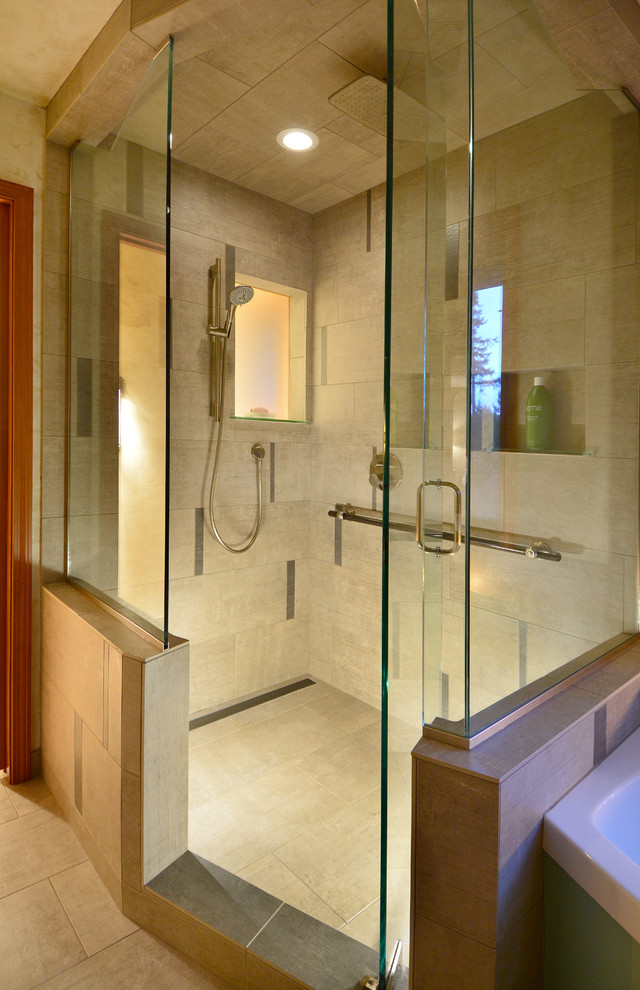 Inspiration for a large transitional master bathroom in Seattle with recessed-panel cabinets, medium wood cabinets, a drop-in tub, a double shower, beige tile, porcelain tile, porcelain floors, a vessel sink and granite benchtops.