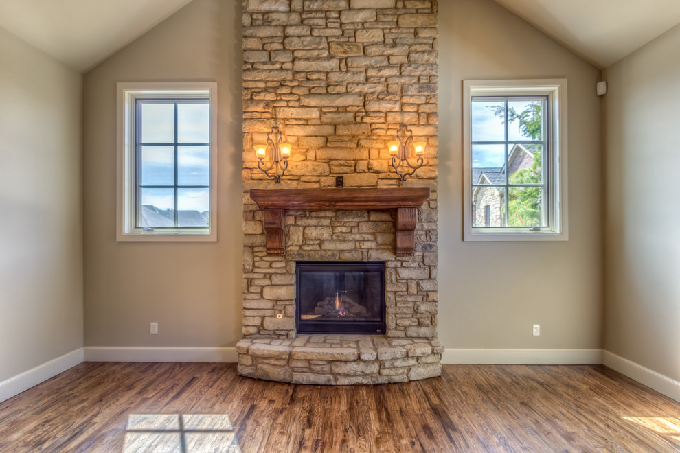 Large country open concept living room in Oklahoma City with beige walls, medium hardwood floors, a standard fireplace and a stone fireplace surround.