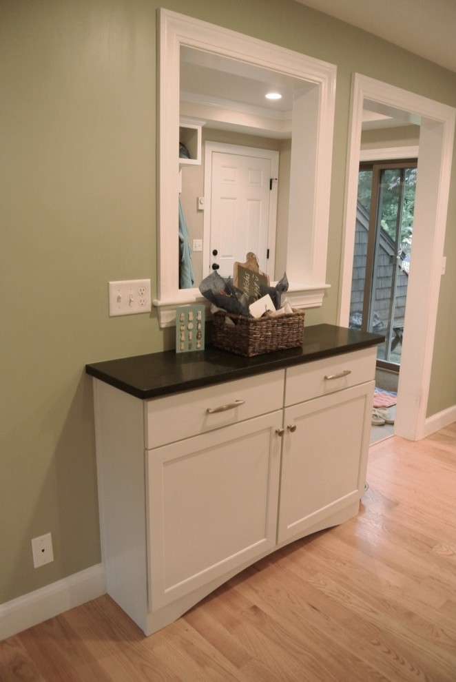 Eat-in kitchen - transitional u-shaped light wood floor eat-in kitchen idea in Boston with an undermount sink, shaker cabinets, white cabinets, beige backsplash, porcelain backsplash, stainless steel appliances, a peninsula and black countertops