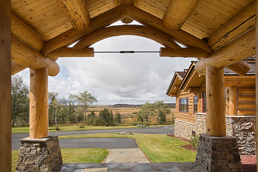 Example of a mountain style medium tone wood floor entry hall design with a medium wood front door