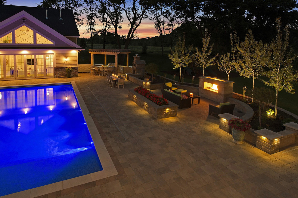 Inspiration for a large traditional backyard rectangular lap pool in Minneapolis with natural stone pavers.