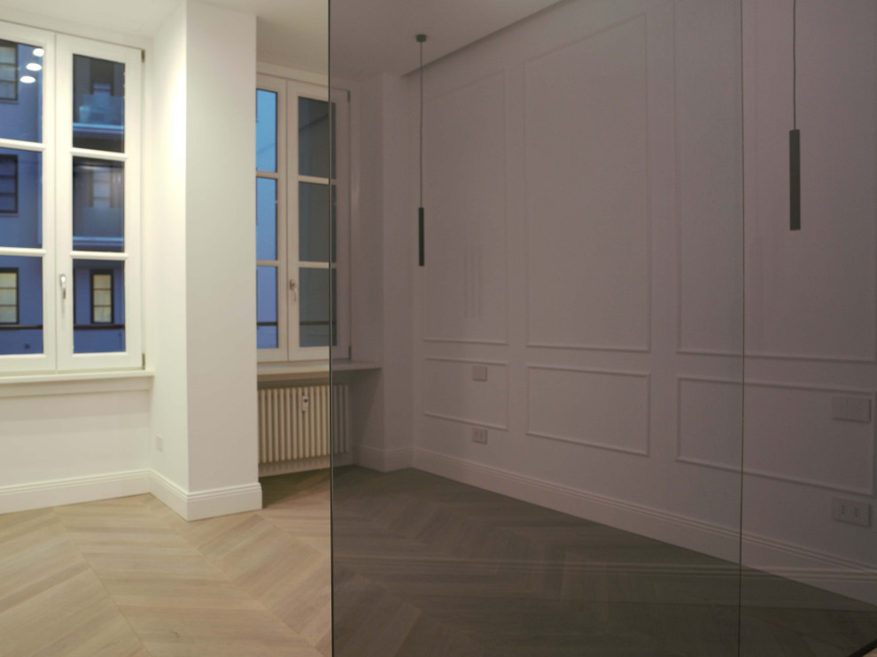 Ejemplo de dormitorio principal minimalista de tamaño medio con paredes blancas, suelo de madera clara y boiserie