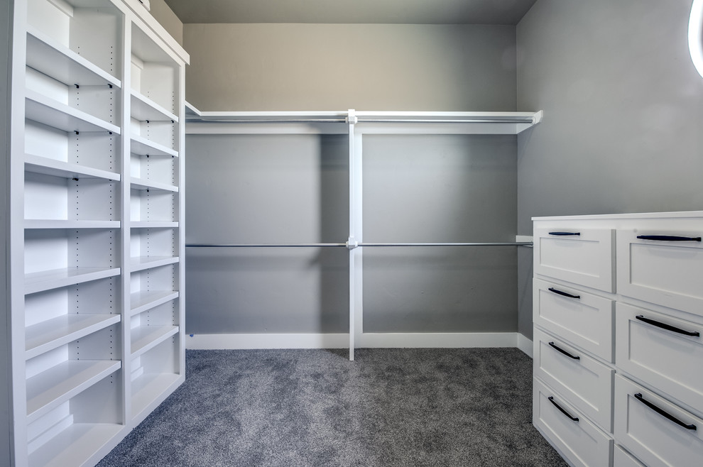 Mid-sized traditional gender-neutral walk-in wardrobe in Austin with shaker cabinets, white cabinets, carpet and grey floor.