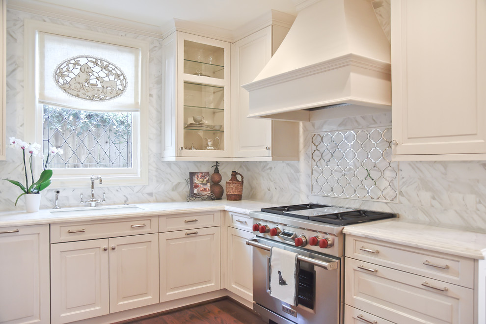 Mid-sized traditional u-shaped separate kitchen in Houston with a drop-in sink, raised-panel cabinets, white cabinets, marble benchtops, white splashback, mirror splashback, stainless steel appliances, dark hardwood floors and no island.