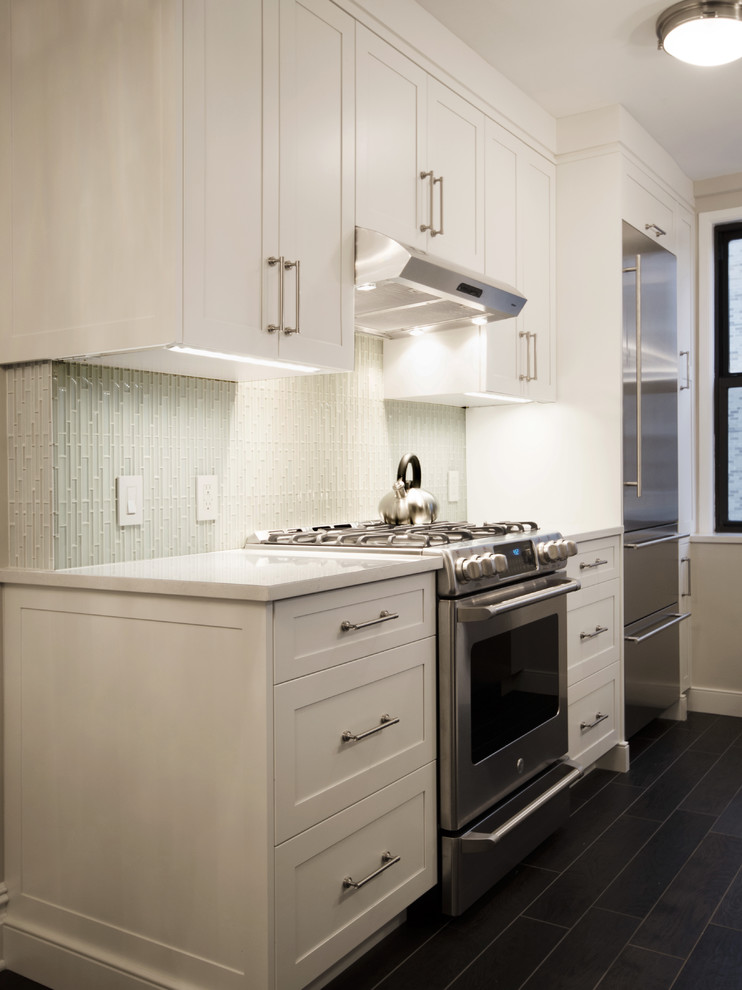 This is an example of a small modern galley eat-in kitchen in New York with with island, shaker cabinets, white cabinets, quartzite benchtops, white splashback, stainless steel appliances, an undermount sink, porcelain floors and glass tile splashback.
