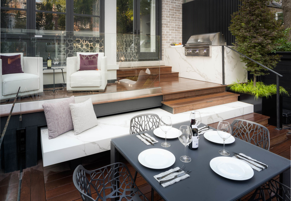 Small modern backyard deck in Toronto with an outdoor kitchen and no cover.