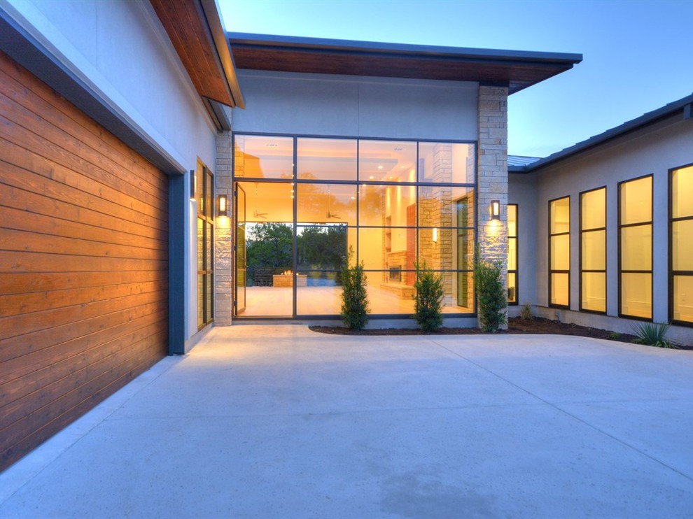 This is an example of a large contemporary one-storey stucco exterior in Austin.