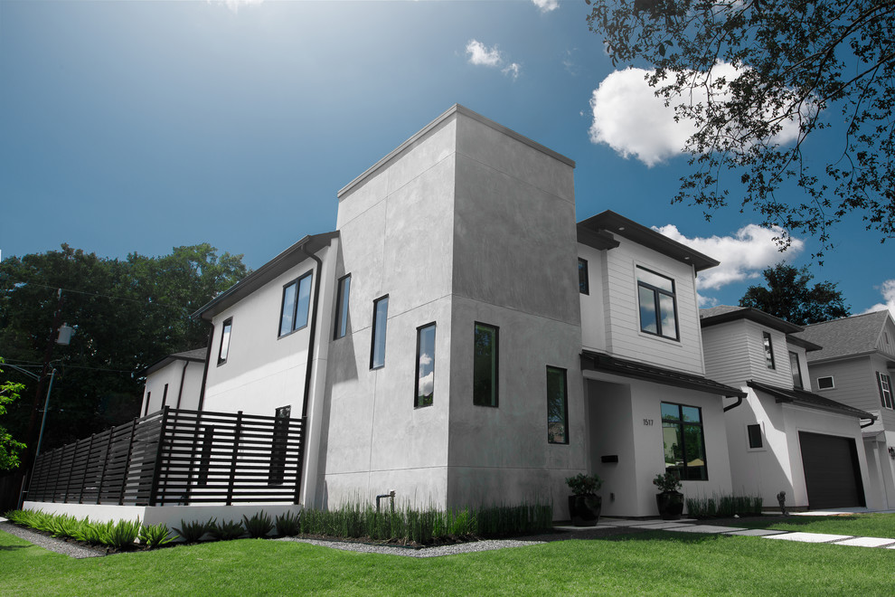 Photo of a mid-sized contemporary two-storey white house exterior in Houston with mixed siding, a flat roof and a metal roof.