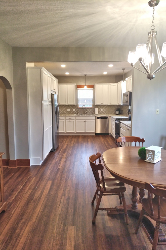 Eat-in kitchen - mid-sized u-shaped laminate floor and brown floor eat-in kitchen idea with a drop-in sink, shaker cabinets, white cabinets, laminate countertops, gray backsplash, ceramic backsplash, stainless steel appliances, no island and beige countertops