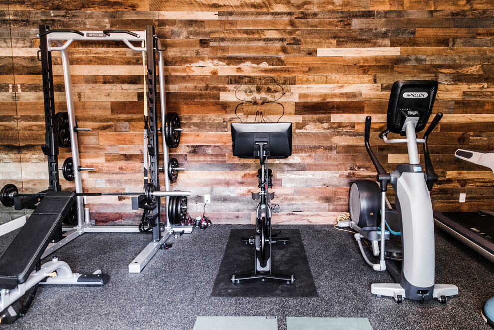 Mid-sized country home weight room in Phoenix with brown walls and black floor.