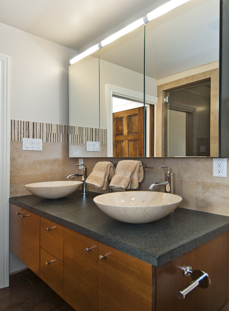 This is an example of a transitional bathroom in San Francisco with a vessel sink, flat-panel cabinets, medium wood cabinets and beige tile.