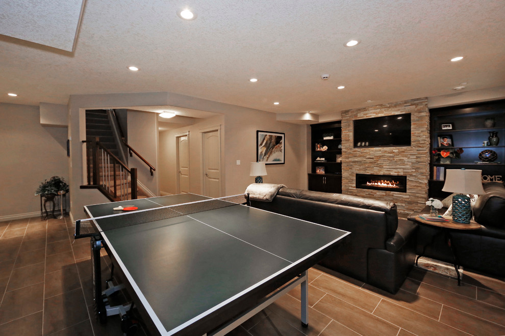 Mid-sized transitional underground basement photo in Edmonton with green walls, a ribbon fireplace and a stone fireplace