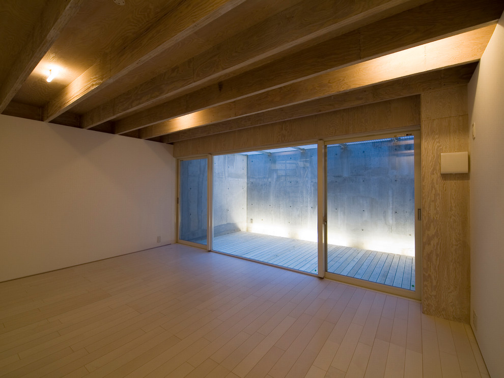 Inspiration for a modern walk-out basement in Tokyo with white walls.