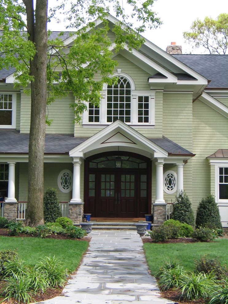 Inspiration for a large traditional two-storey green exterior in New York with wood siding and a gable roof.