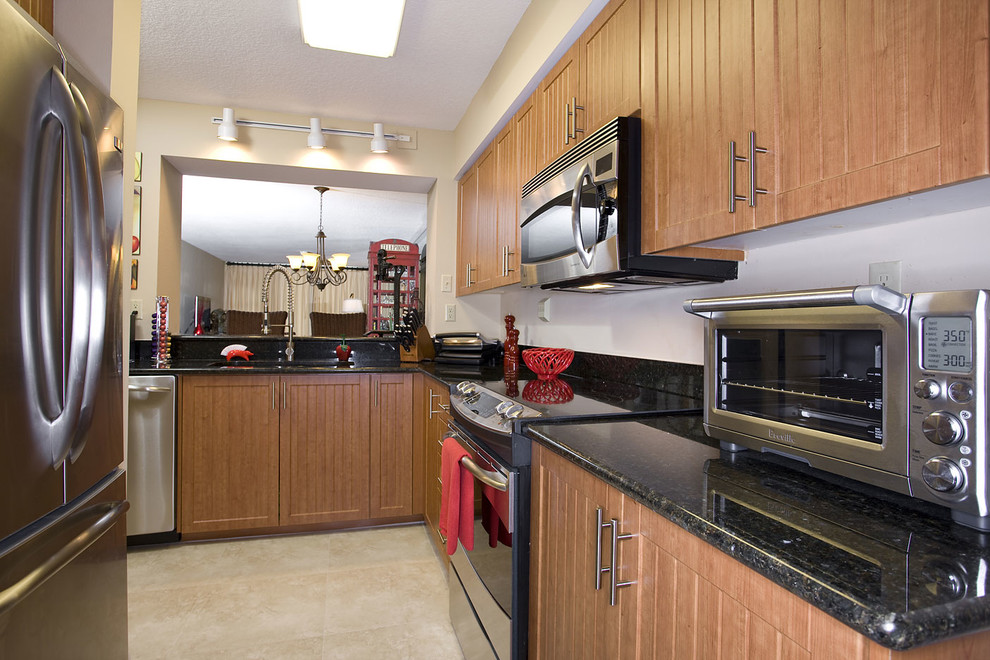 Mid-sized arts and crafts single-wall eat-in kitchen in Tampa with a single-bowl sink, louvered cabinets, light wood cabinets, recycled glass benchtops, white splashback, stainless steel appliances, limestone floors and beige floor.