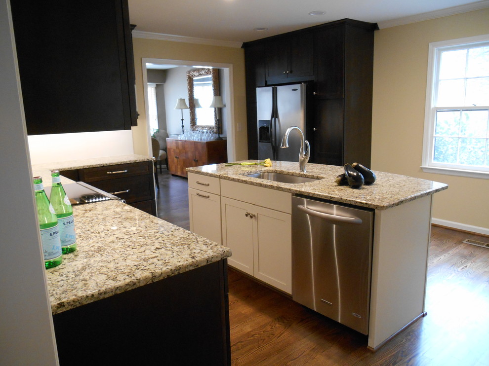 Inspiration for a transitional u-shaped eat-in kitchen remodel in Birmingham with an undermount sink, shaker cabinets, dark wood cabinets, granite countertops, white backsplash, ceramic backsplash and stainless steel appliances