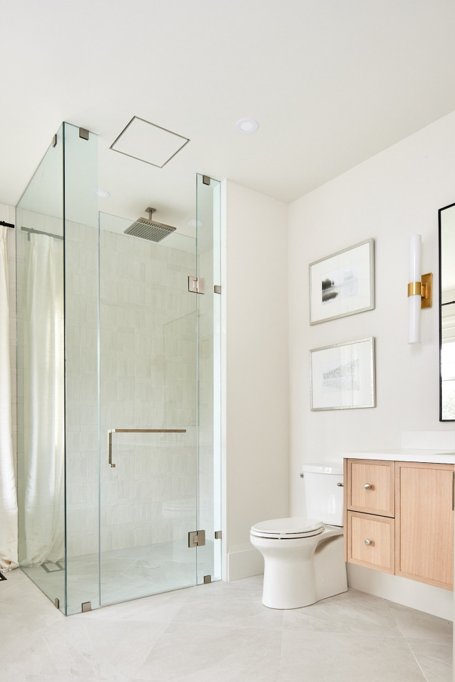 Mid-sized transitional 3/4 porcelain tile, beige floor and single-sink walk-in shower photo with flat-panel cabinets, light wood cabinets, white walls, an integrated sink, quartz countertops, a hinged shower door, white countertops and a floating vanity