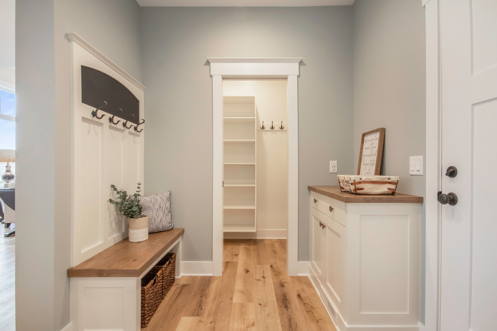 This is an example of a transitional mudroom in Grand Rapids with grey walls, vinyl floors, a single front door and a white front door.