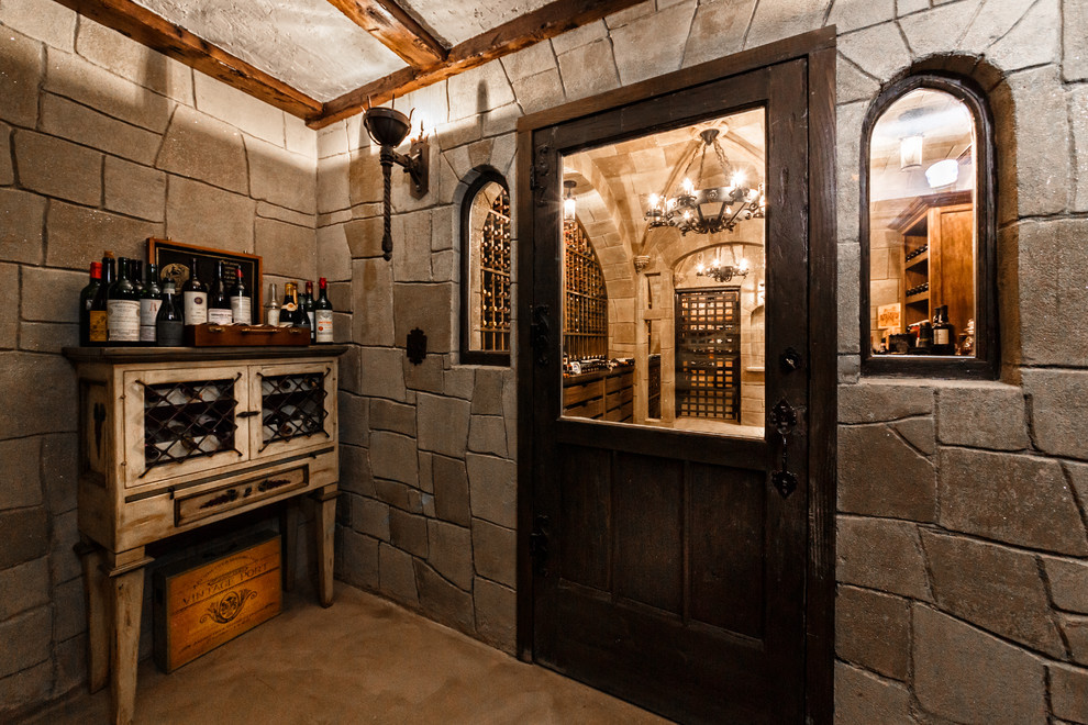This is an example of an expansive transitional wine cellar in New York with brick floors and display racks.