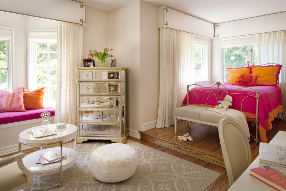 Design ideas for a mid-sized eclectic kids' bedroom for kids 4-10 years old and girls in Los Angeles with medium hardwood floors and pink walls.