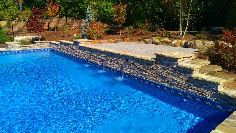 Photo of a mid-sized contemporary backyard rectangular natural pool in St Louis with stamped concrete.