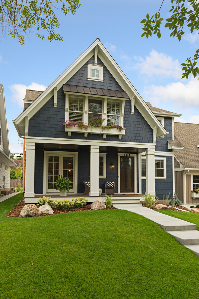 This is an example of a mid-sized traditional blue house exterior in Minneapolis with wood siding and a shingle roof.