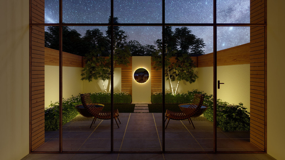 Immagine di un piccolo giardino minimalista esposto a mezz'ombra dietro casa in estate con pavimentazioni in pietra naturale e recinzione in legno