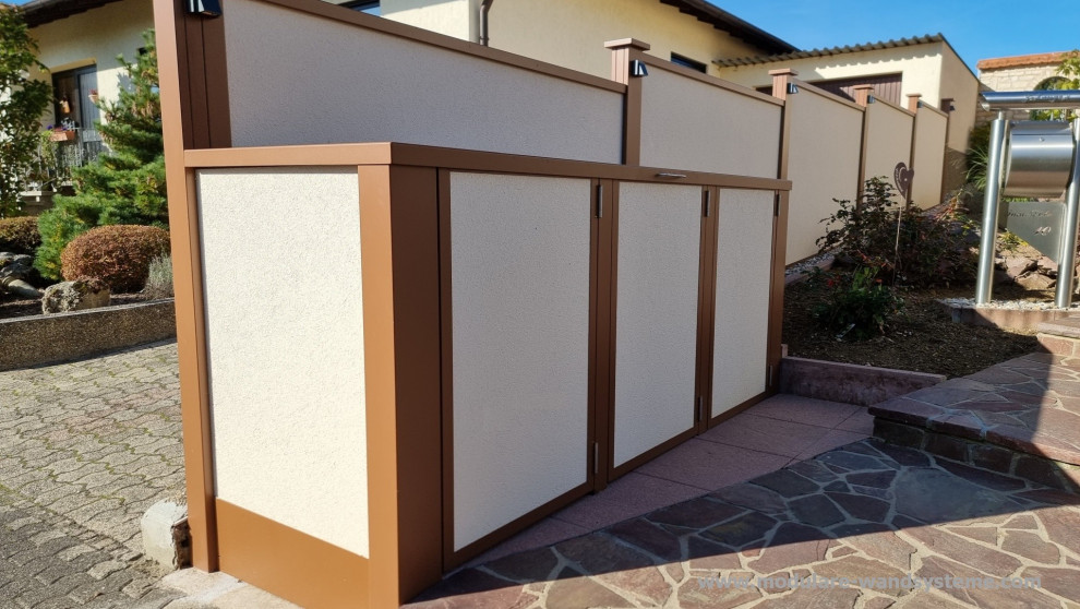 Foto di un piccolo vialetto d'ingresso moderno esposto in pieno sole davanti casa in estate con un muro di contenimento, pavimentazioni in pietra naturale e recinzione in metallo